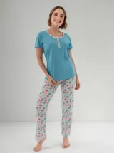 Pijama compuesto por una remera celeste de manga corta con escote redondo y botonera frontal, y un pantalón largo blanco con estampado tropical de sandías y hojas.