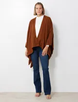 Ruana de tejido soft, color marrón óxido, de corte amplio y sin cierres, con cuello redondo.