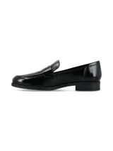 Mocasín de cuero charolado color negro, con diseño clásico de antifaz en el empeine y suela plana con pequeño tacón.