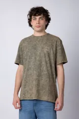 Remera de algodón con efecto de lavado desgastado tipo snow wash, de corte semi-oversize, cuello redondo y manga corta. Presenta un pequeño estampado gráfico circular en el pecho.
