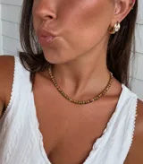 Collar de cristales checos facetados en tonos tierra y dorados, con pequeñas cuentas esféricas de acero con baño de oro.