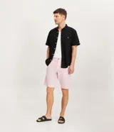 Bermuda de hombre confeccionada en una mezcla de lino y algodón, con diseño recto, cierre frontal de botón y cremallera, trabillas para cinturón y bolsillos laterales.