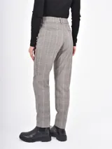 Pantalon de vestir de corte recto y tiro medio, con estampado de cuadros en tonos grises. Cuenta con bolsillos laterales y cierre frontal con botón y cremallera.