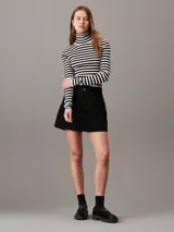 Sweater ajustado de punto a rayas horizontales blancas y negras, con cuello alto y mangas largas.