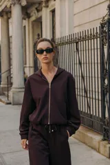 Sudadera con capucha y manga larga, con cierre frontal de cremallera, bolsillos delanteros de doble vivo y bajo ajustable con elástico interior.