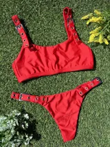 Conjunto de bikini rojo con hebillas metálicas plateadas y bombacha colaless.