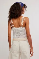 Musculosa corta y semitransparente de encaje floral negro, con tirantes ajustables.