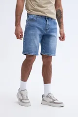 Bermuda de jean de corte recto y largo a la rodilla, con diseño clásico de cinco bolsillos y lavado desgastado.