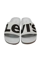 Sandalias tipo slides blancas con el logo de Le-vi's en negro.
