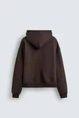 Sudadera con capucha de corte relajado, color marrón oscuro, con interior perchado. Presenta un bolsillo frontal tipo canguro, bordado con la palabra 'LOVE' en el pecho y un parche decorativo a contraste en el bolsillo. Posee puños y ruedo en rib.