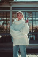 Sweater de punto grueso color blanco, con cuello tortuga y mangas semi anchas, tejido a mano en lana merino.