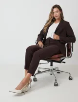 Pantalón sastrero slim color marrón oscuro, de tiro alto con pretina anatómica, pinzas verticales frontales y cierre oculto. Tiene bolsillos laterales inclinados y pinzas traseras para un ajuste favorecedor.