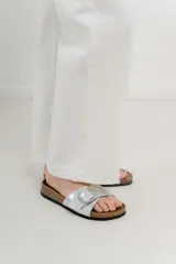 Sandalias plateadas con hebilla metálica, plantilla anatómica y base marrón.