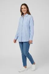 Camisa de manga larga con diseño de rayas verticales celestes y blancas, cuello camisero, cierre frontal de botones y un bolsillo ojal en el pecho.