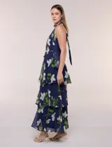 Vestido maxi Julia Jordan de gasa estampada azul con flores blancas y hojas verdes, escote halter y diseño estructurado en paneles volados.
