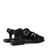 Sandalias franciscanas de cuero negro con tiras cruzadas, suela plana y hebilla metálica dorada lateral.