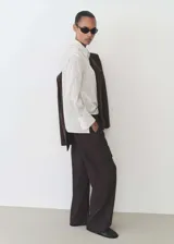 Pantalon cargo de corte recto y tiro medio, confeccionado en tejido fluido. Presenta cintura con elástico y cordón de ajuste, bolsillos laterales y bolsillos de parche con solapa en las piernas.