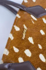 Cartera tipo baguette color negro con textura efecto cocodrilo, diseño alargado, doble asa de mano y cierre superior.