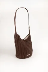 Cartera tipo hobo de color negro, con diseño plisado en toda su superficie y correa ajustable con hebilla metálica. Presenta una placa metálica decorativa en la parte inferior frontal.