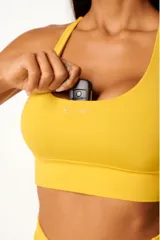 Top deportivo de alto rendimiento con diseño de espalda nadador, confeccionado en tejido técnico con protección UV50+. Presenta un bolsillo interno en el forro frontal y detalles reflectivos.