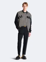 Remera de manga corta con estampado de monograma jacquard en tonos marrón y beige. Cuello redondo negro y parche con logo Balmain en el pecho.