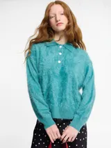 Sweater de punto de cachemira color turquesa con cuello polo y cierre frontal de tres botones. Presenta una textura suave tipo pelo, manga larga y terminaciones acanaladas en puños y ruedo.
