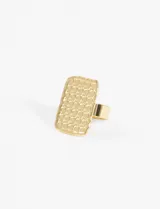 Anillo plateado de acero quirúrgico hipoalergénico con forma rectangular y superficie texturizada con pequeños círculos.