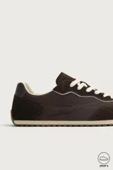 Zapatilla deportiva barefoot de hombre, confeccionada en combinación de piezas de piel con acabado serraje en color marrón, con cordones y suela fina de goma en contraste.