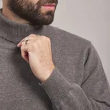 Polera color beige de tejido de punto con cuello alto.