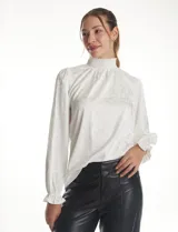 Blusa de gasa labrada color blanco, con cuello alto en punto smock, mangas largas con terminación fruncida y diseño elegante.