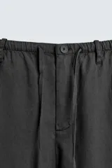 Pantalón de corte regular fit confeccionado en mezcla de algodón y lino. Presenta cintura elástica con cordón ajustable, cierre frontal con cremallera y botón, bolsillos laterales y bolsillo trasero de vivo con botón.