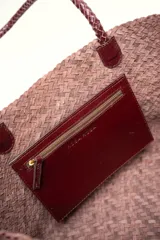 Cartera tote de cuero vacuno trenzado a mano, color bordó, de diseño espacioso con asas firmes.