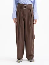 Pantalon de corte ancho y tiro alto, color marron, confeccionado en poplin elastizado. Presenta tablas en la cintura que aportan volumen, cierre frontal y un lazo ajustable con argollas metalicas.