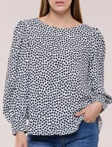 Blusa de manga larga abullonada con estampa geométrica en blanco y negro, escote redondo y puños anchos.
