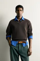 Jersey de punto tejido en hilatura de algodón con cuello en pico y manga larga, de corte regular fit y acabados en rib.