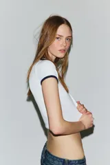 Camiseta negra de manga corta y cuello redondo, con vivos a contraste en el cuello y las mangas.