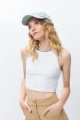 Top básico sin mangas, color blanco, de tejido acanalado y corte ajustado al cuerpo, con cuello redondo a la base.