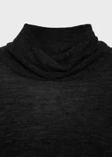 Jersey de punto fino con diseño semitransparente, cuello alto y manga larga. Presenta un corte recto y tejido de textura ligera.
