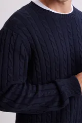 Buzo de punto con diseño de ochos, color azul marino, con cuello redondo y puños y ruedo acanalados.