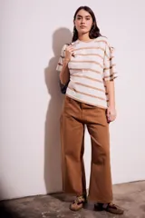 Remera de algodón color crudo con rayas horizontales color café, de corte oversize y mangas cortas.