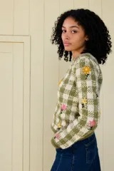 Sweater tejido en jacquard de cuadros bicolor verde y crudo, elaborado en lana merino, con delicados bordados florales hechos a mano.