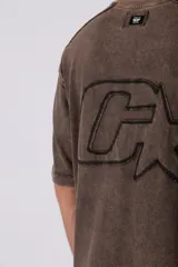 Remera de algodón gris con efecto acid wash, corte regular, mangas cortas y cuello redondo. Cuenta con un pequeño bordado tono sobre tono en el pecho y una etiqueta lateral distintiva de la marca en el ruedo.
