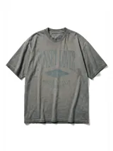 Remera de jersey con efecto teñido, color marrón, de corte holgado y cuello redondo. Presenta un estampado frontal con texto en tonos más oscuros.