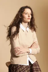 Cardigan negro de tejido suave y liviano, con cierre frontal abotonado y cuello redondo.