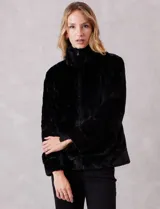 Chaqueta de piel sintética de alta densidad, con silueta recta, cuello alto envolvente y cierre frontal oculto. Cuenta con bolsillos laterales y forro interno a tono.