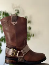 Bota de cuero marrón con estribo desmontable plateado.