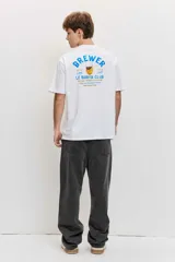 Remera blanca de algodón con cuello redondo, manga corta y pequeño estampado en el pecho.
