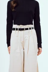 Pantalón marrón de corte ancho y talle alto, con pinzas frontales y bolsillos laterales.