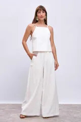 Blusa blanca sin mangas con tirantes finos y escote cuadrado.