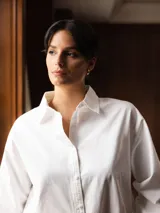 Camisa de algodón color blanco, de corte clásico y manga larga con cierre frontal de botones.